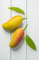 Mango fruit on white wooden background photo