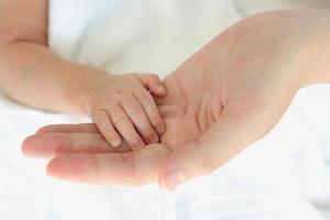 Closeup baby's hand with her mom, Healthy with mother for new family concept photo