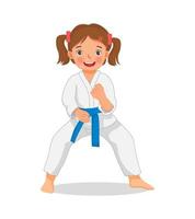 linda niña de karate con cinturón azul que muestra técnicas de defensa de manos posa en la práctica de entrenamiento de artes marciales vector