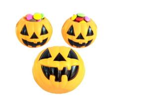 Halloween pumpkin face with colorful candy inside isolated over white photo