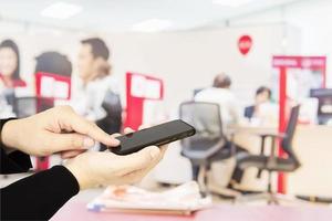 A man is using telephone over colorful blurred bokeh light in office and people background photo
