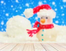 White wooden planks over blurred model snowman on a white background and blue decorated Christmas and New Year. photo