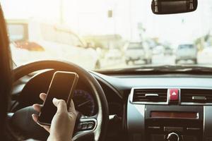 primer plano de un hombre conduciendo un coche peligrosamente mientras usa el teléfono móvil foto