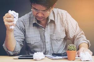 Man working seriously with crumpled paper in his hand photo