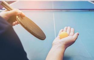 un hombre juega tenis de mesa listo para servir foto