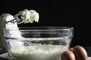 material preparado para hacer pastel de crema usando una máquina mezcladora portátil eléctrica foto