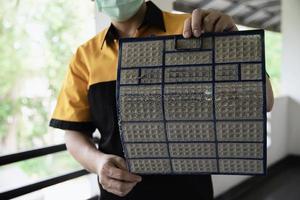 hombre de mantenimiento de aire acondicionado que muestra una pantalla sucia preparándose para limpiar durante la temporada de calor en tailandia foto