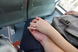 first time couple lovers hand holding together on the bus. photo