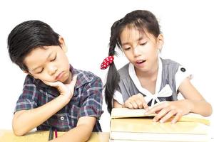 Sister try to teach her naughty younger brother to read a book isolated over white background photo