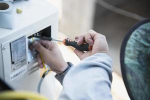 Man is installing wall compressor of air conditioner during hot season photo