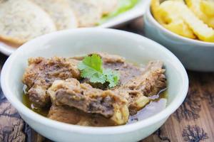 Pork stew serve with French fries and garlic bread photo