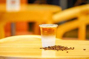 quitar café con leche con granos de café alrededor de la mesa de madera foto