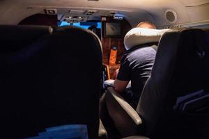 A man read book on the small private jet plane at the night under the light. photo