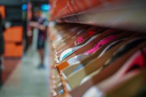 muchas zapatillas deportivas en las cajas de papel naranja en el estante listas para la venta. foto