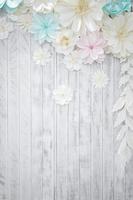 Pastel paper flower cream white pink green blue colour with hand craft art on the white wood plate background. photo