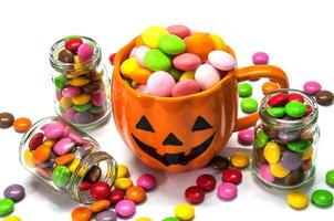 Halloween pumpkin face buckets with colorful candy photo