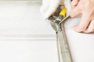 Man is working with mosquito wire screen installation photo