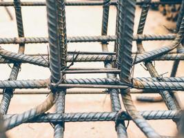 Vintage style photo of selective focused steel rods in reinforced concrete footing and column preparation in construction site.