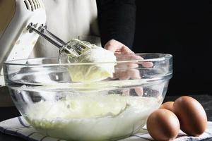 señora haciendo pastel poniendo crema con espátula - concepto de cocina de panadería casera foto