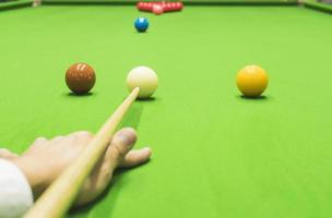 Man begin playing snooker with first strokes photo
