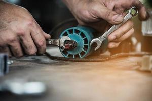 hombre que prepara la máquina herramienta cortadora de laminado del enrutador eléctrico - concepto de taller de carpintería foto