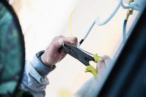 Man is installing wall compressor of air conditioner during hot season photo