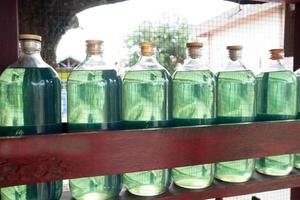 selective focus on glass bottles containing 1 liter pertalite fuel that are sold at retail photo