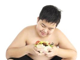 A boy is happily looking at sandwich isolated over white photo