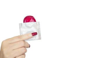 Lady's hand showing red condom and package with white copy space background. photo