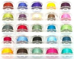 Box of colorful bobbins on white background photo