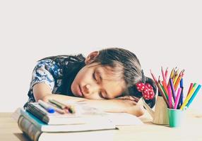 el tono vintage de un niño asiático está durmiendo mientras lee un libro grande foto