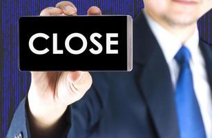 Focused of close word on mobile phone screen in blurred young businessman hand and digital technology background photo