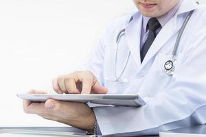 Doctor is working with tablet over white background photo