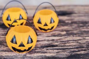 Empty Halloween pumpkin face buckets on old wooden texture photo