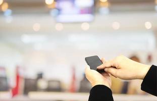 A man is using telephone over colorful blurred bokeh light in office and people background photo
