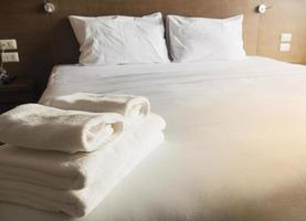 juego de toallas y ropa de cama blanca en un hotel moderno foto