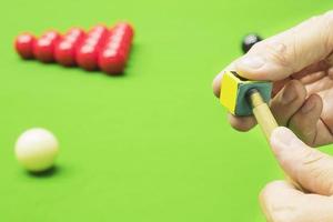 Man using chalk while playing snooker photo