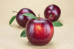 manzana roja fresca sobre fondo marrón suave - concepto de fondo de fruta fresca foto