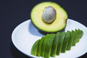 Fresh ripe sliced avocado on white plate ready to eat photo