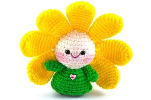 Happy baby flower, handmade crochet doll on white background photo