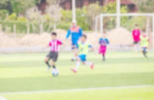 foto borrosa de niños practicando fútbol en el campo de fútbol