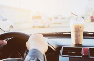 Man driving car with cup of cold coffee photo