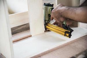 carpintero que trabaja con la preparación de productos de muebles de madera utilizando herramientas manuales y estación de mesa de máquina foto