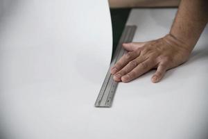 Man using measure hand tool doing wallpaper cutting work in home construction site, people with hand tool object concept photo