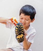 A boy is happily cleaning his shoe photo