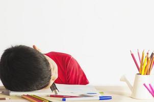 Asian children were asleep while doing homework. photo