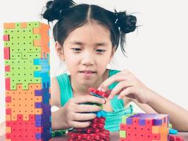 el tono vintage de un niño asiático está jugando un juego creativo de bloques de plástico para practicar su habilidad física y mental foto