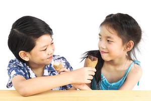 los niños asiáticos están comiendo helado foto