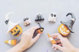 Girl is playing Halloween clay toy of jack o lantern pumpkin faces photo