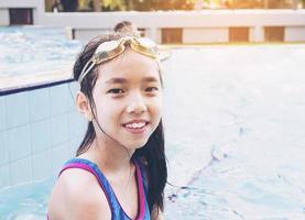 niño asiático feliz en la piscina foto